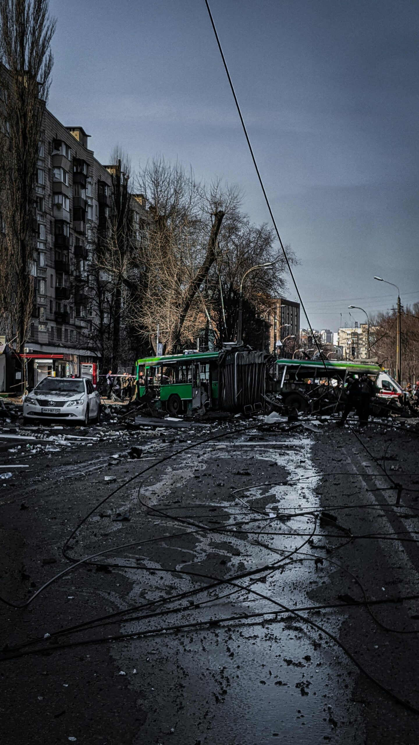 Debris and vehicles on a city street in Kyiv after a serious accident. Captured under a moody sky.