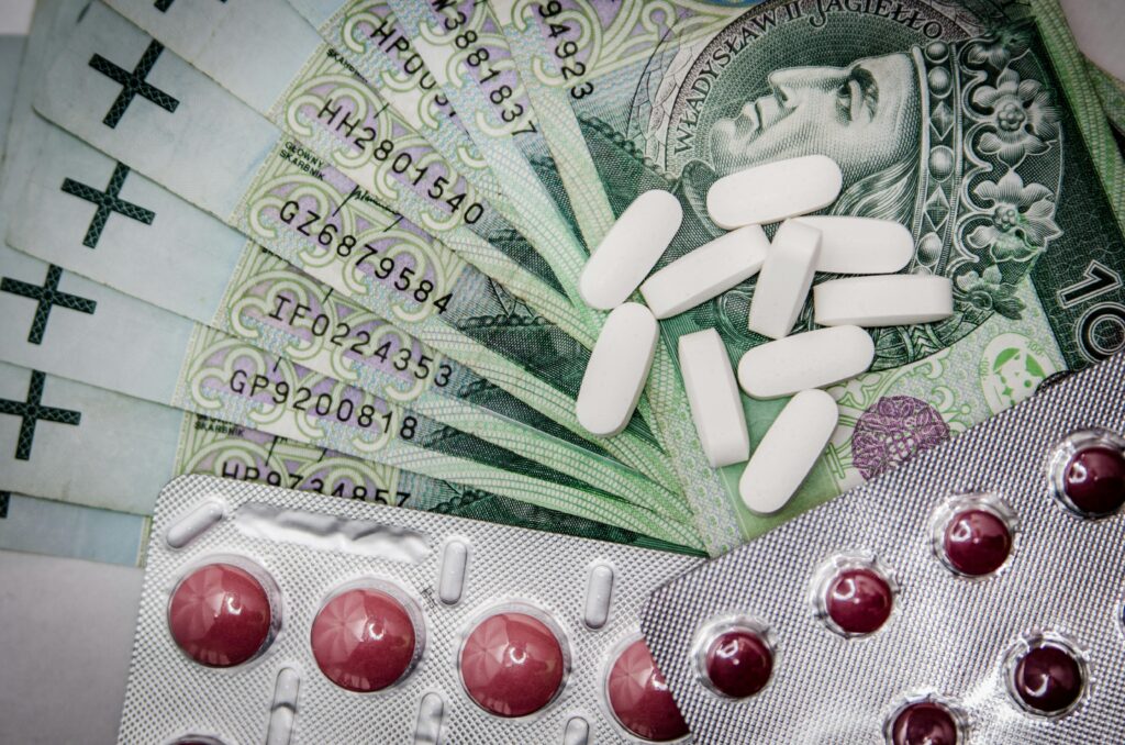 medications-money-cure-tablets-47327-47327 Polish 100 złoty notes with pills and blister packs, illustrating medical costs.