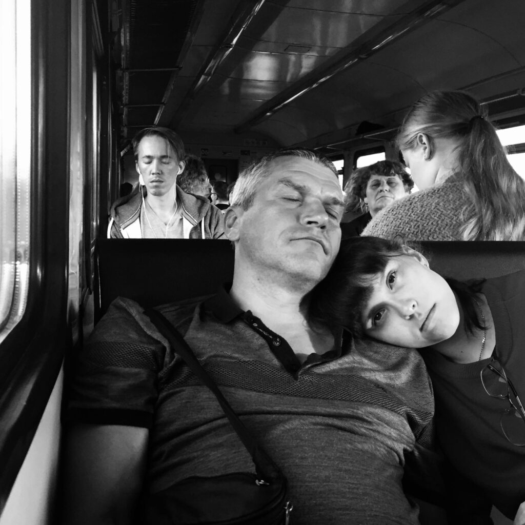 pexels-photo-8667431-8667431 Black and white portrait of passengers resting inside a train, creating a serene mood.