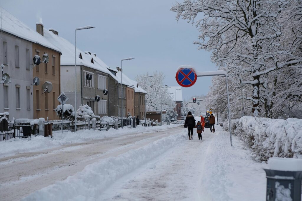 pexels-photo-30866060-30866060 A picturesque winter street with people walking among snow-covered buildings and trees.