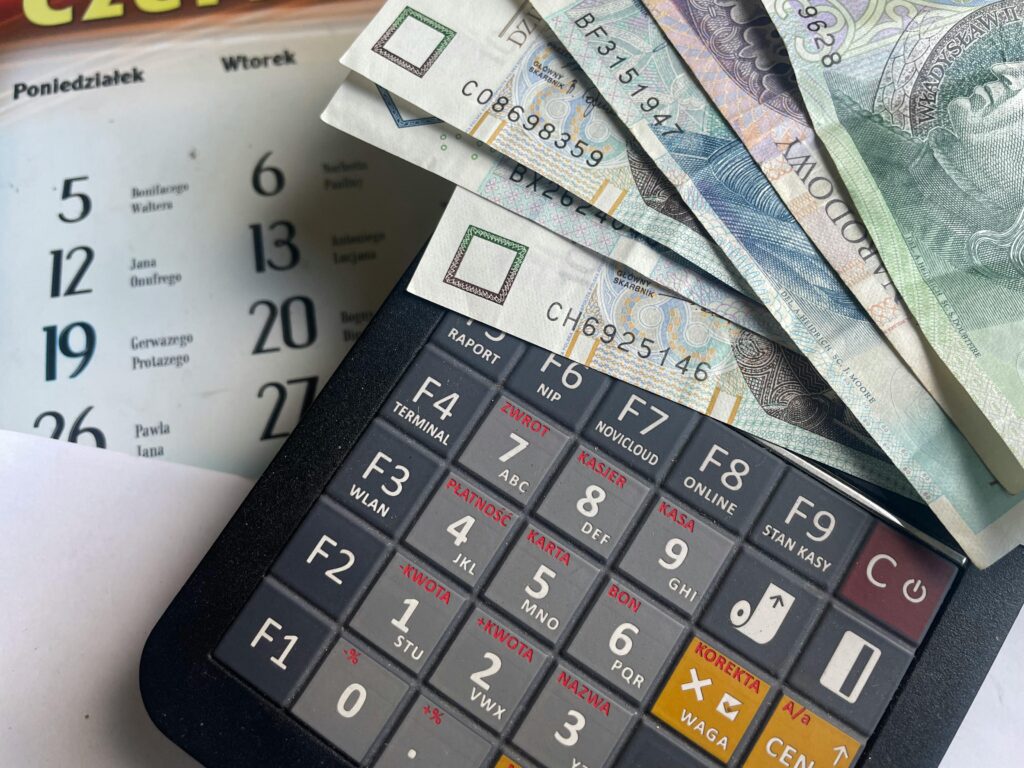 pexels-photo-34240091-34240091 Close-up of Polish Zloty banknotes on a calculator with a calendar in the background.