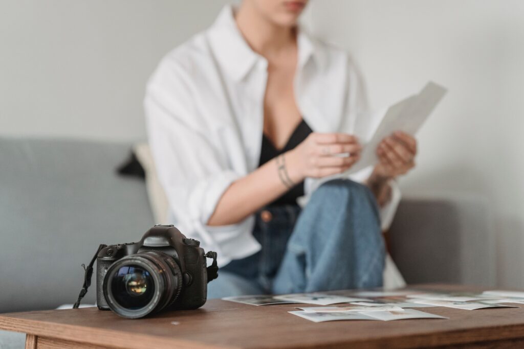 pexels-photo-7014427-7014427 Crop unrecognizable tattooed woman sitting on sofa against table with professional photo camera in house
