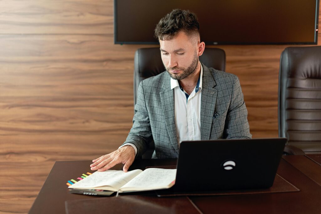pexels-photo-8937586-8937586 Focused man working on laptop and notes in a modern office.